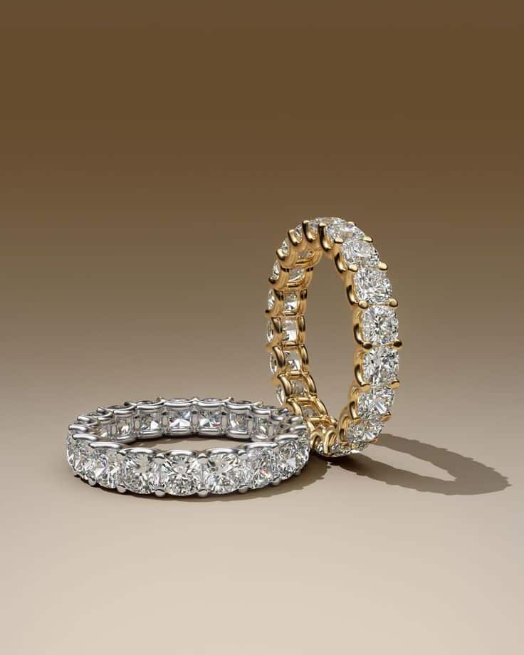 Two sparkling diamond eternity rings, one gold and one silver, on a gradient brown background, elegant and luxurious.