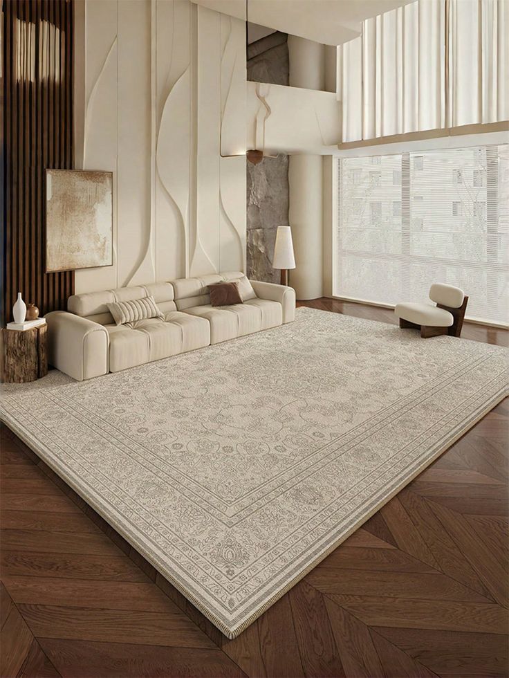 Contemporary living room with large patterned rug, beige sofa, wooden floor, and natural light through sheer curtains.