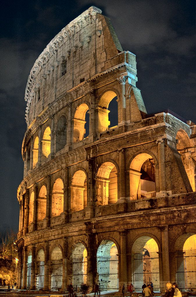 Colosseum illuminated at night showcasing ancient Roman architecture.