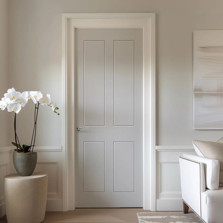 Minimalist interior with a white panel door, orchid plant on a stand, and modern decor elements.