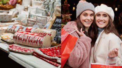Festive market shopping: two women enjoying holiday purchases with red gifts and seasonal crafts at an outdoor market.