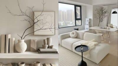 Modern minimalist living room with neutral decor, featuring a white sofa, abstract art, and natural light from large windows.