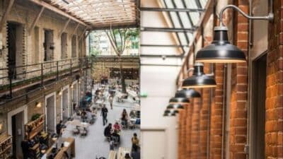 Modern urban cafe with industrial design, featuring exposed brick, hanging lights, and a glass ceiling.