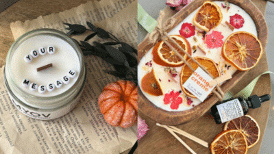 Custom scented candles with dried orange and floral garnishes on a rustic table, perfect for cozy home decor.