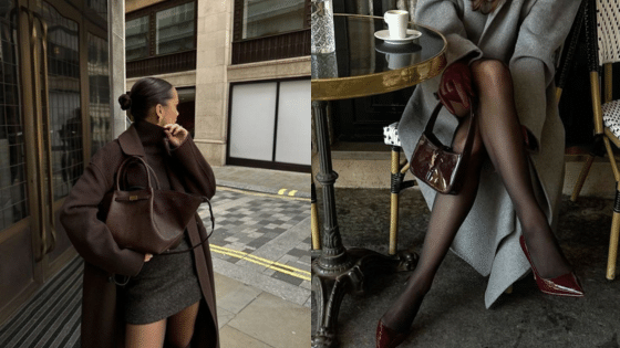 Viewing Deck Blog копия 23 Stylish woman in a brown coat and handbag, sitting at a café table with crossed legs, showcasing chic fashion. | Sky Rye Design Stylish woman in a brown coat and handbag, sitting at a café table with crossed legs, showcasing chic fashion.