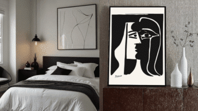 Modern bedroom with abstract wall art, featuring black and white decor and framed painting on a wooden dresser.