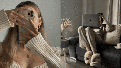 Cozy home setup with person using a smartphone and laptop, dressed comfortably in beige tones, enhancing a relaxed vibe.