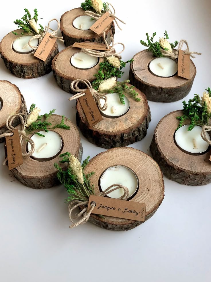 Rustic wooden candle holders with greenery and tags, perfect for weddings or home decor.