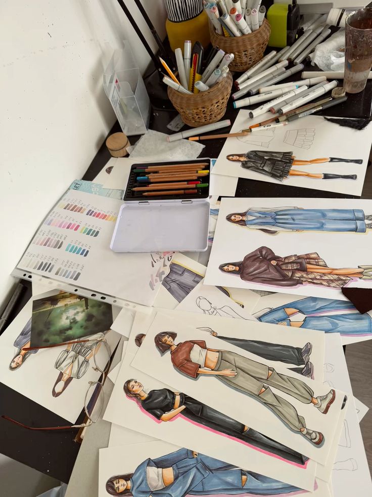 Fashion design sketches and drawing tools on a creative workspace desk.