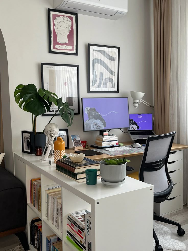 Modern home office with dual monitors, bookshelves, plants, and framed art on walls. Cozy workspace setup.
