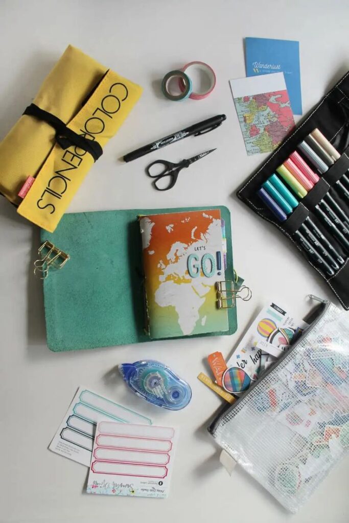Travel journal with colorful stationery, pencils, scissors, and map, perfect for creative planning adventures.