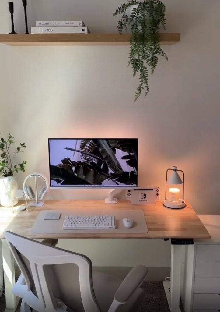 Minimalist home office setup with a monitor, keyboard, and plants, ideal for productivity and comfort.