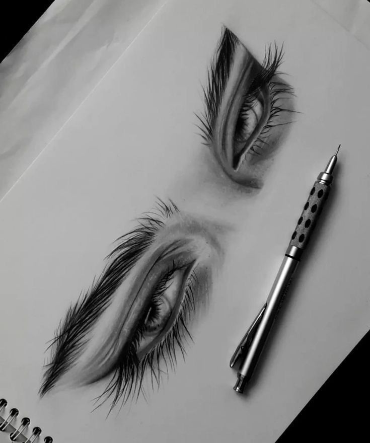Detailed pencil sketch of expressive eyes with pen on paper, showcasing shading and artistic precision.