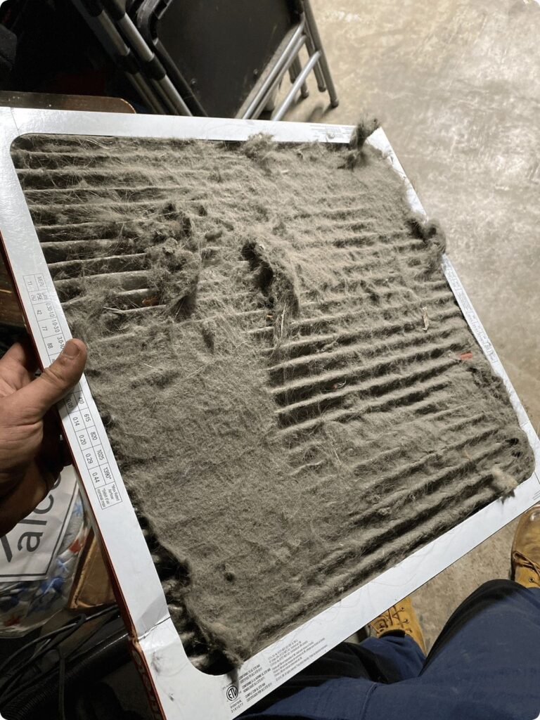 Dirty air filter covered in dust and debris, needing replacement for better HVAC efficiency.
