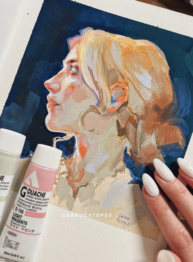 Portrait painting of a woman using gouache, with two paint tubes and a hand with manicured nails holding the artwork.