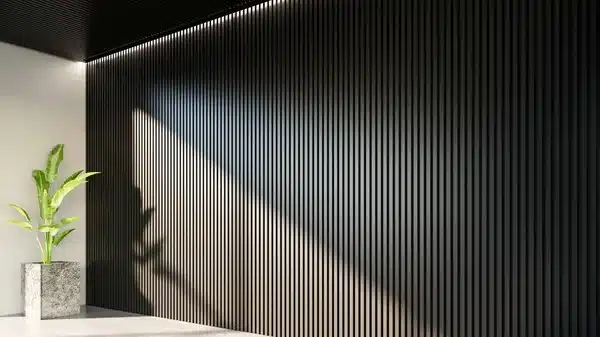 Modern interior with vertical black slat wall and potted plant, highlighted by sunlight. Minimalist decor and architecture.