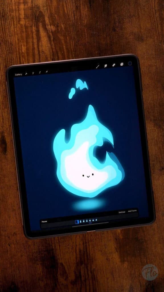 Cute animated blue flame displayed on a tablet screen with a wooden background.