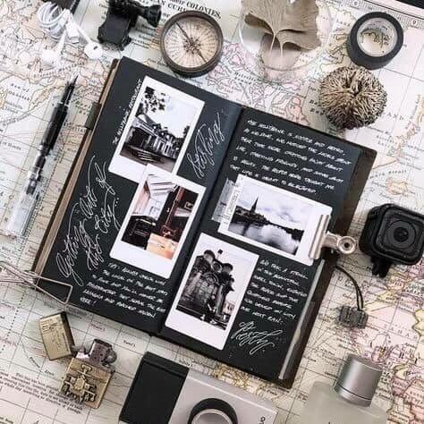 Travel scrapbook open on a vintage map, surrounded by photography gear and travel keepsakes.