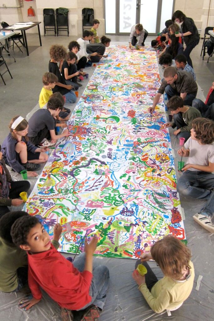 Children painting a colorful mural together in an art class.