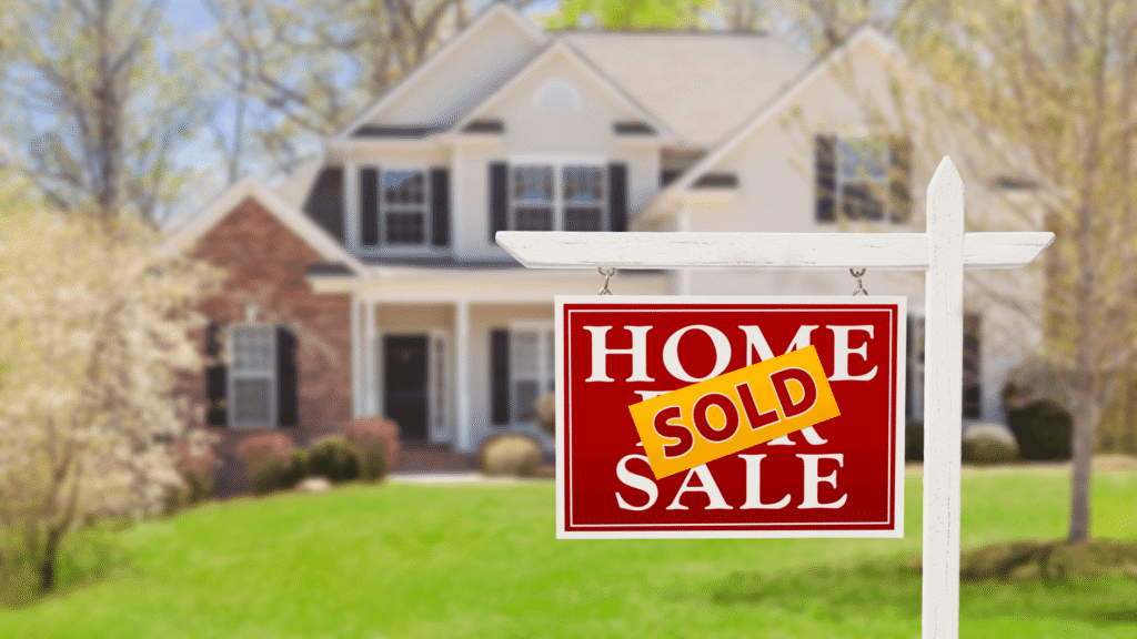 House with sold sign in front yard, indicating successful real estate transaction in a suburban neighborhood.