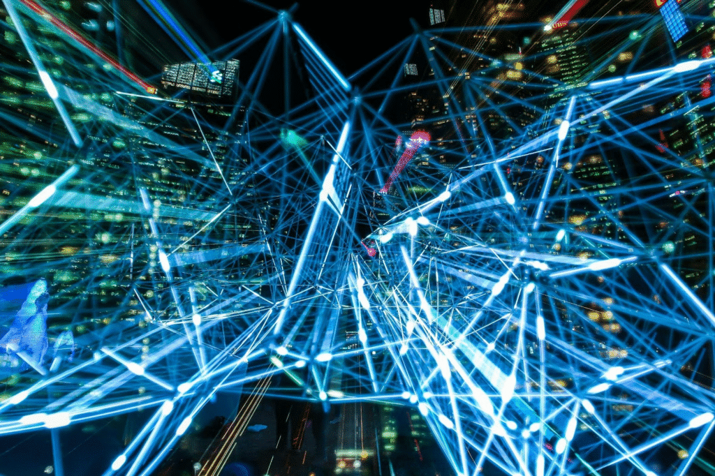 Futuristic cityscape with glowing blue digital networks illustrating technology and connectivity at night.