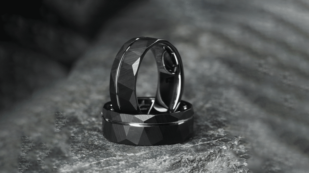 Two faceted black rings on a textured stone background.