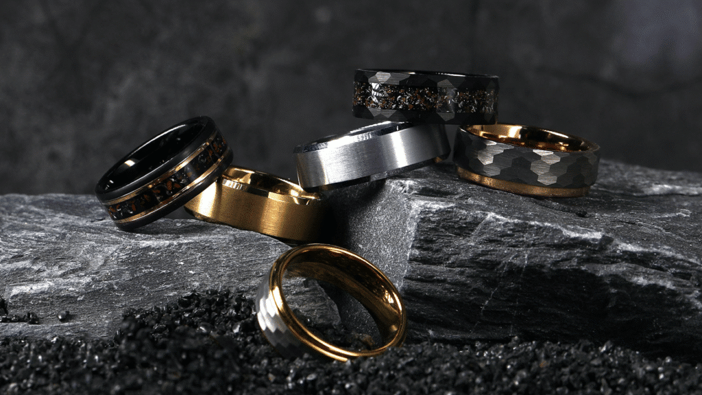 image Six stylish men's rings in various metals displayed on a textured rock for a modern, rugged look. | Sky Rye Design Six stylish men's rings in various metals displayed on a textured rock for a modern, rugged look.