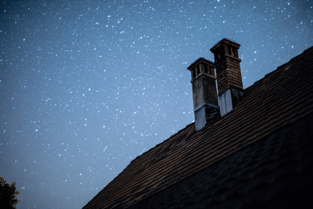 image1 Brick chimneys on a tiled roof under a starry night sky. | Sky Rye Design Brick chimneys on a tiled roof under a starry night sky.