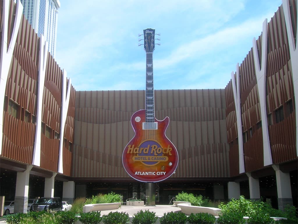 Giant guitar at Hard Rock Hotel and Casino entrance in Atlantic City under blue sky.