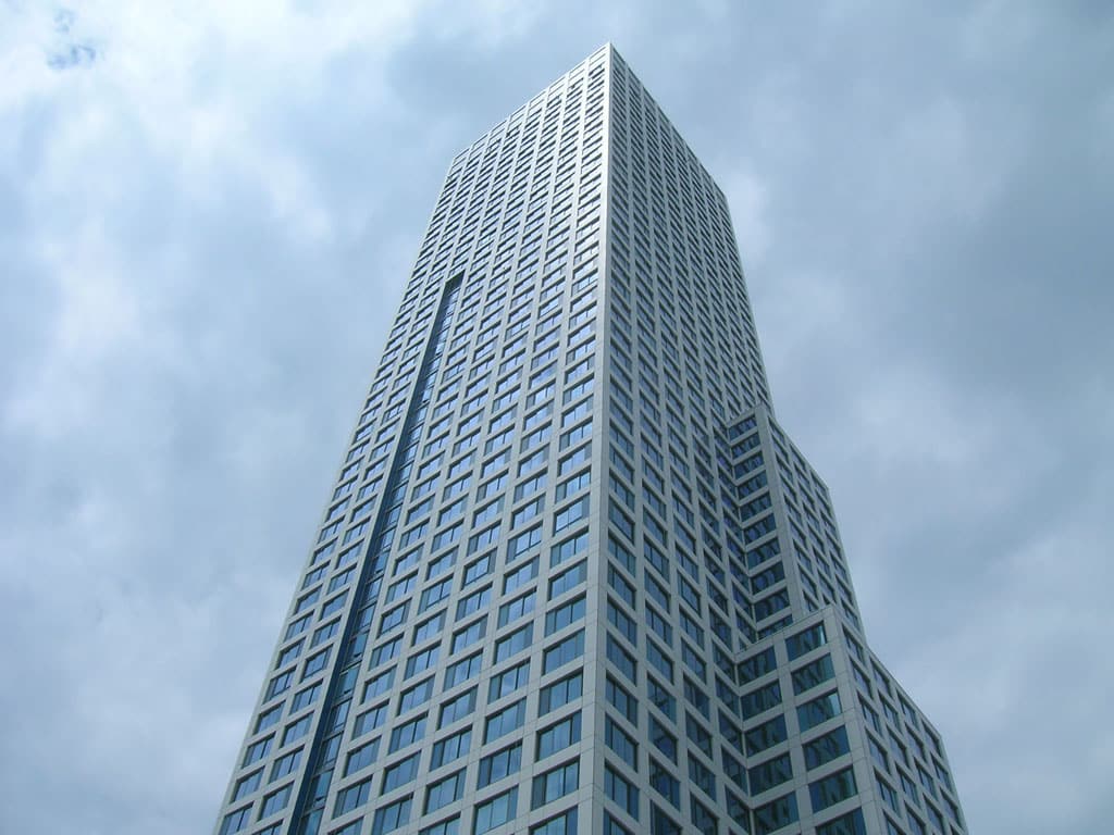 Modern high-rise building against a cloudy sky, showcasing urban architecture and skyline design.
