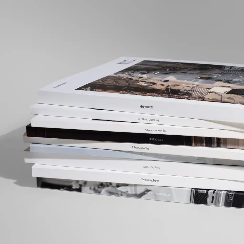 Stack of travel-themed books featuring destinations like New York, Queenstown, and Melbourne on a neutral background.