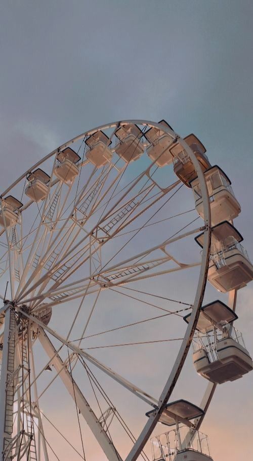 _ Ferris wheel against a pastel sunset sky, offering a serene amusement park scene. | Sky Rye Design Ferris wheel against a pastel sunset sky, offering a serene amusement park scene.