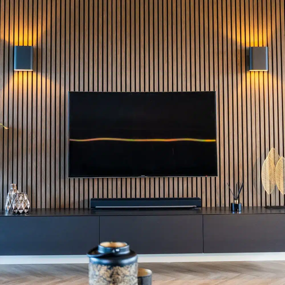 Modern living room with a wall-mounted TV, striped wood panel wall, sleek decor, and ambient lighting.
