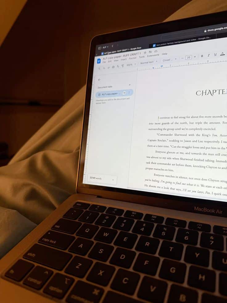 Open laptop displaying a document draft on Google Docs with cozy evening lighting.