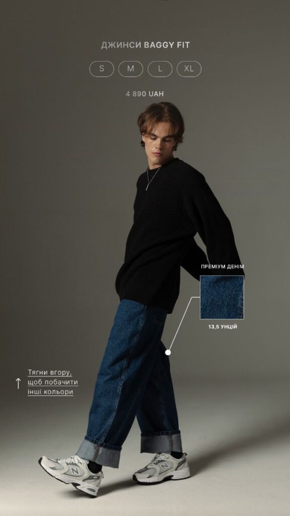 Model wearing baggy fit jeans and black sweater, showcasing premium denim and sneaker style. Available in sizes S-XL.