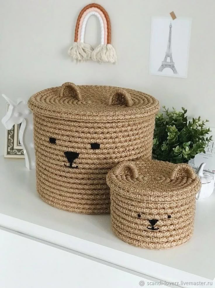Cute woven baskets with bear faces on a white shelf, wall art and plant in background, stylish home decor.