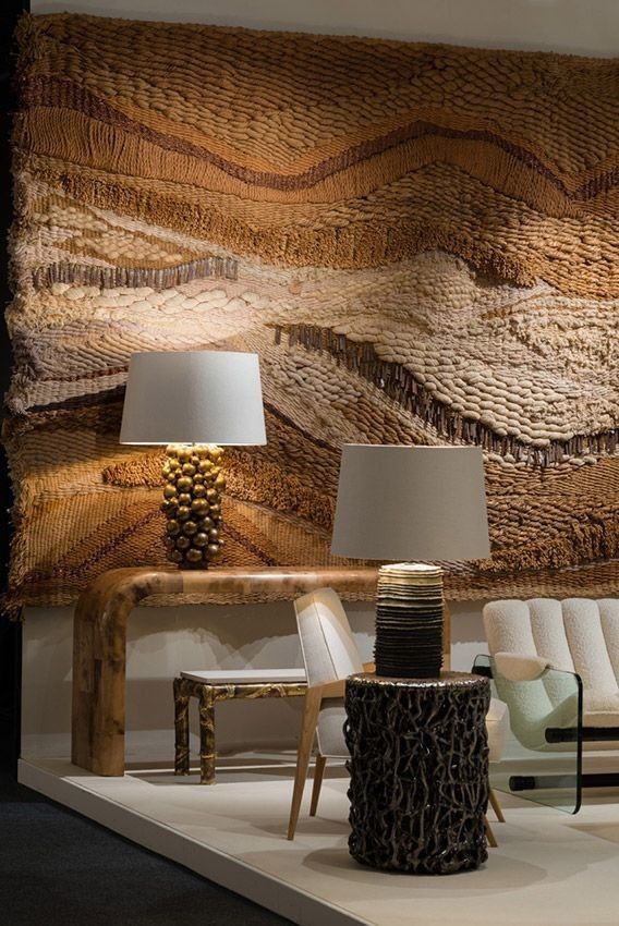 Cozy living room with textured wall art, modern lamps, and rustic furniture for a warm, inviting atmosphere.