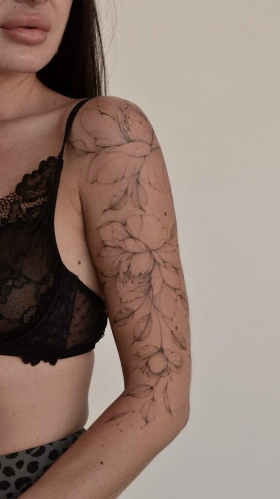 Тату цветы tattoo flowers inst _ s_samayeva Elegant floral tattoo on woman's arm, wearing black lace bralette, expressing artistic body ink style. | Sky Rye Design Elegant floral tattoo on woman's arm, wearing black lace bralette, expressing artistic body ink style.