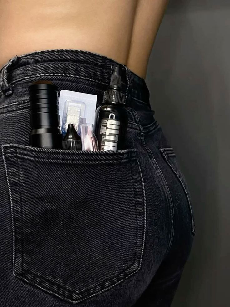 Фон для ваших постов Tattoo supplies in back pocket of black jeans, featuring ink and equipment, against a dark background. | Sky Rye Design Tattoo supplies in back pocket of black jeans, featuring ink and equipment, against a dark background.
