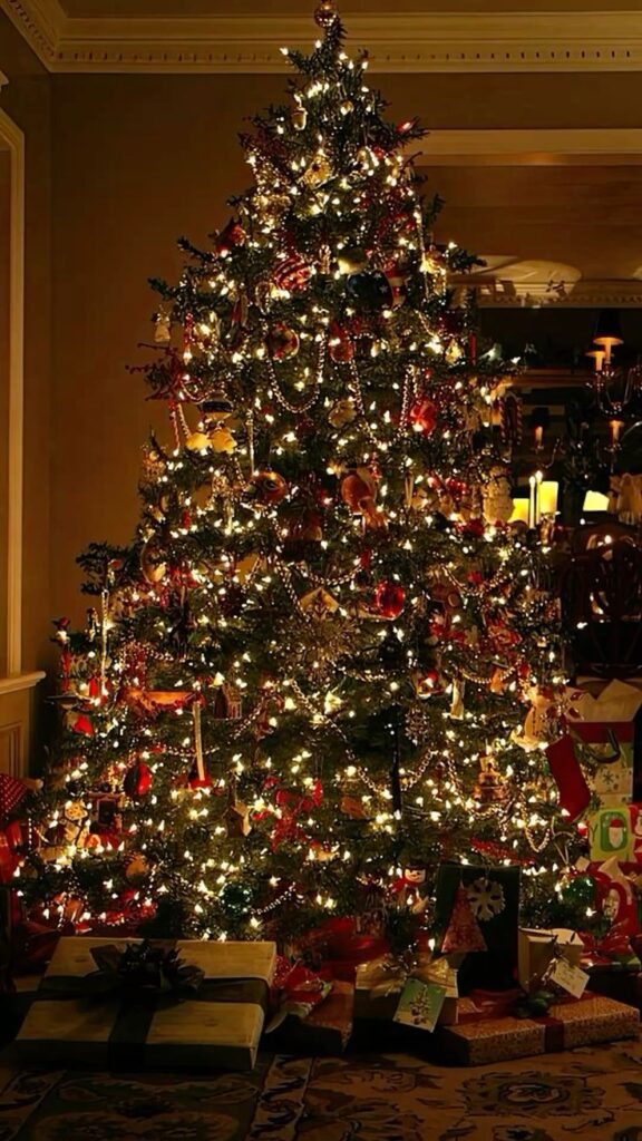 обои Festive Christmas tree glowing with lights and ornaments, surrounded by wrapped presents in a cozy room. | Sky Rye Design Festive Christmas tree glowing with lights and ornaments, surrounded by wrapped presents in a cozy room.