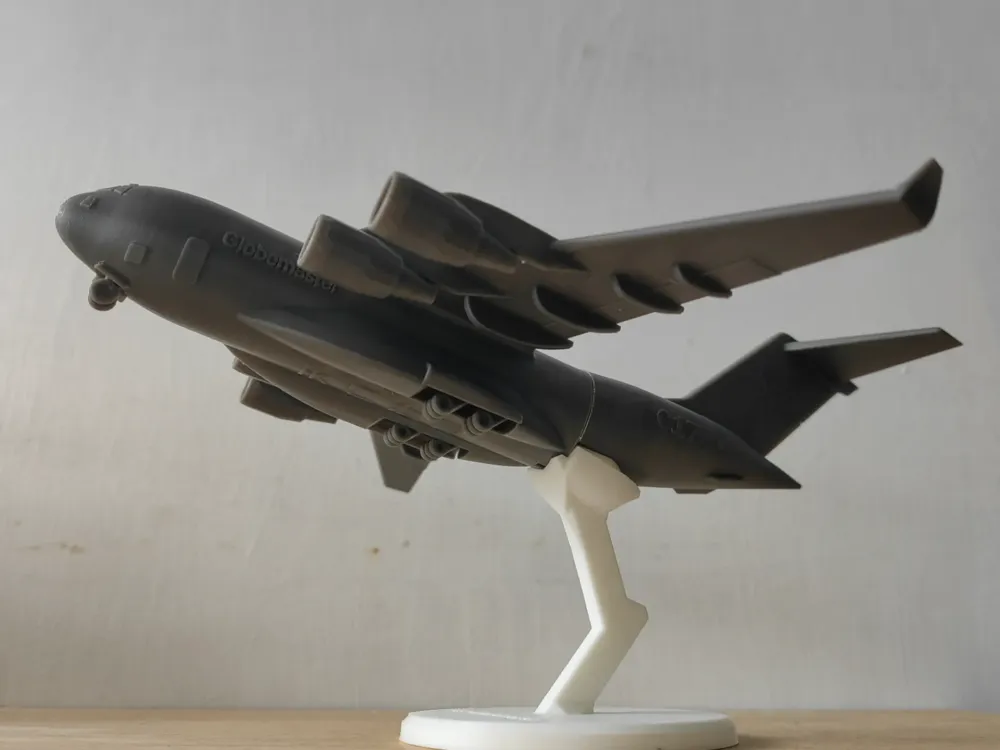 Model of a C-17 Globemaster military aircraft on display, showcasing detailed design and structure on a stand.