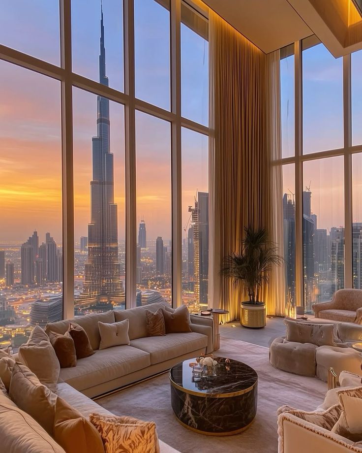 Luxury penthouse with city skyline views and sunset, featuring modern decor and cozy seating area.