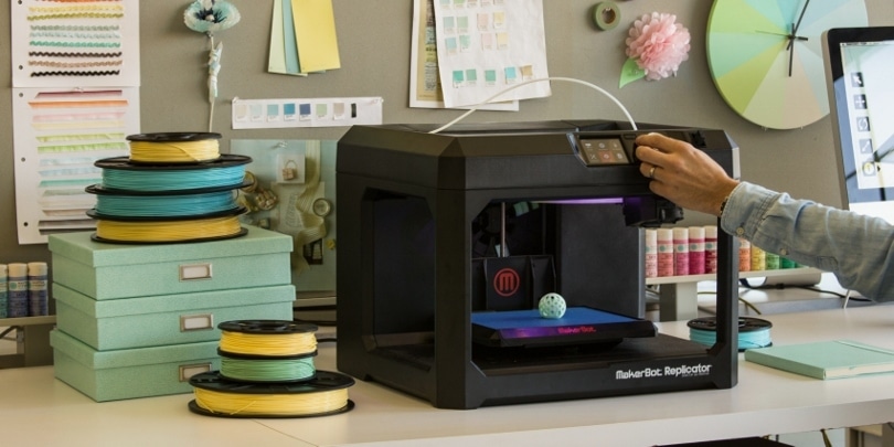 07ExN12oY9HHl6GO0f5b2kU-1v1569489102 3D printer in a creative workspace with colorful filament spools, producing a small spherical object. | Sky Rye Design 3D printer in a creative workspace with colorful filament spools, producing a small spherical object.