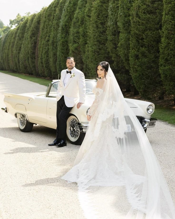 _ 1 Bride and groom pose stylishly by a vintage car, surrounded by lush greenery. | Sky Rye Design Bride and groom pose stylishly by a vintage car, surrounded by lush greenery. wedding photos