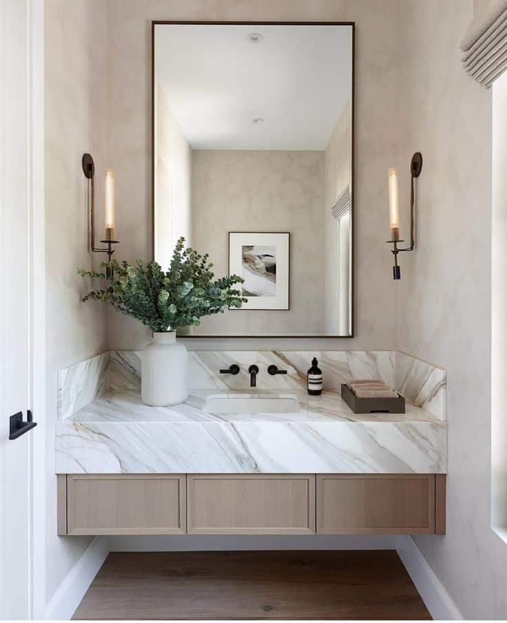 _ 1 Modern bathroom with marble sink, wall mirror, plants, and stylish sconces. Elegant design with neutral tones. | Sky Rye Design Modern bathroom with marble sink, wall mirror, plants, and stylish sconces. Elegant design with neutral tones.