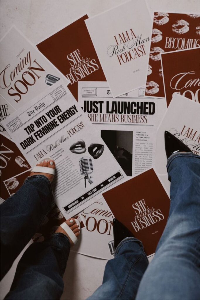 Papers on the floor promoting I Am A Rich Man Podcast and She Means Business Podcast with feet standing.