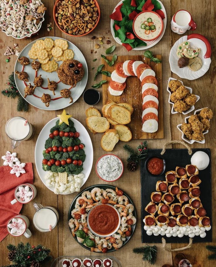 Festive holiday appetizer spread with crackers, dips, shrimp cocktail, veggies, and treats on a rustic wooden table.