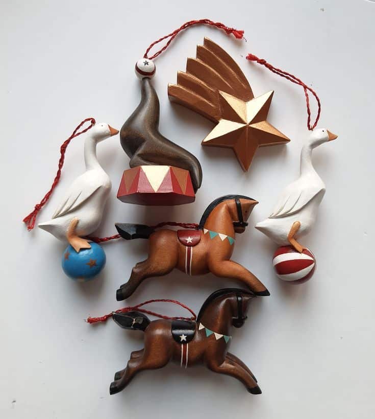 _ 1 Assorted wooden ornaments featuring geese, horses, a star, and an acrobat ideal for festive decoration. | Sky Rye Design Assorted wooden ornaments featuring geese, horses, a star, and an acrobat ideal for festive decoration.