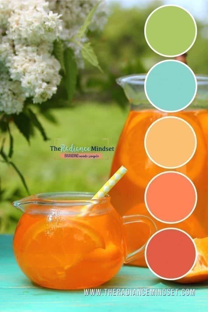 Refreshing orange drink in a glass jar with a striped straw, surrounded by flowers and vibrant color swatches.