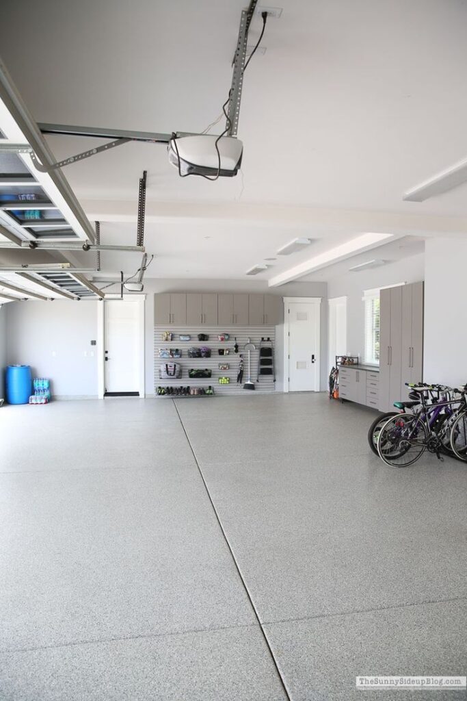 Organized garage with bicycles, storage cabinets, and open space for vehicles.
